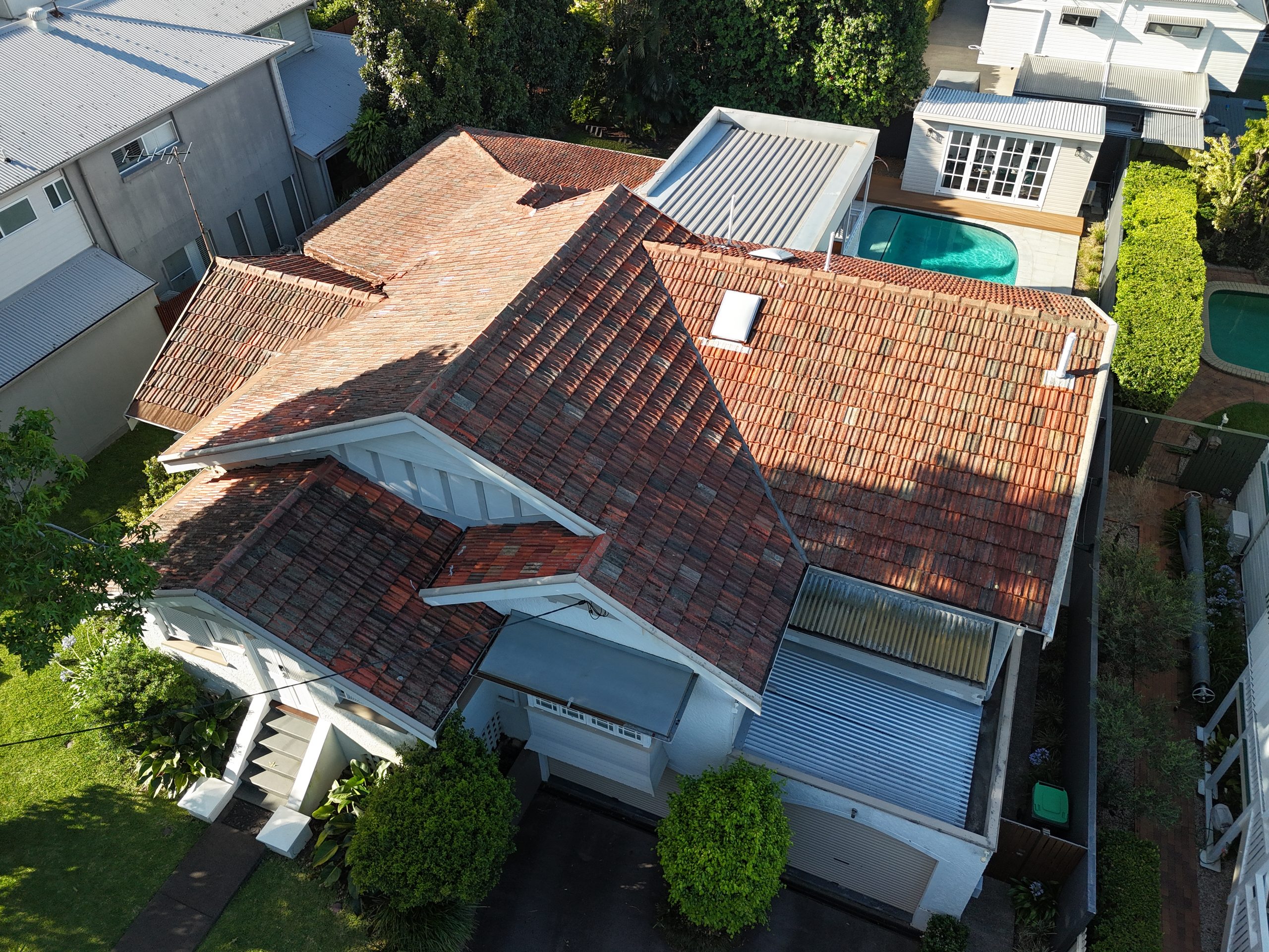 Aerial view of a house with a weathered terracotta tile roof, swimming pool and established garden in Ascot, Brisbane.