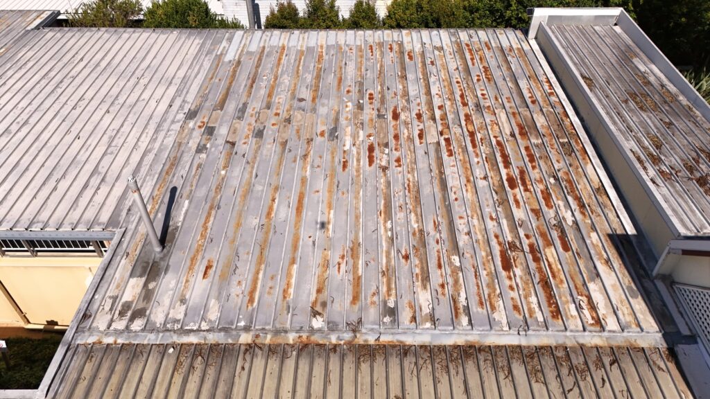 Aerial view of a corroded, weathered metal roof